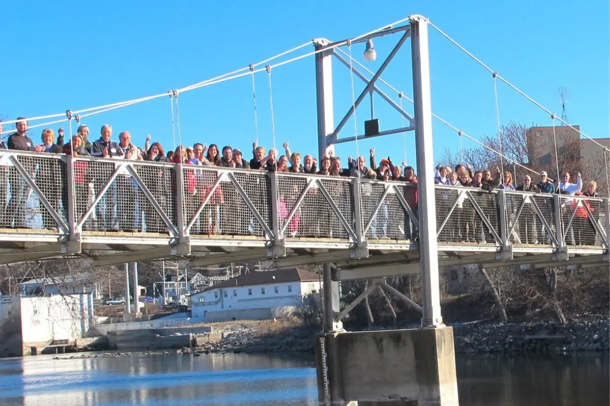 People gathered on the walking bridge over the Minnesota River in Granite Falls