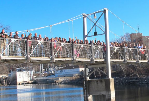 People gathered on the walking bridge across the Minnesota River in Granite Falls