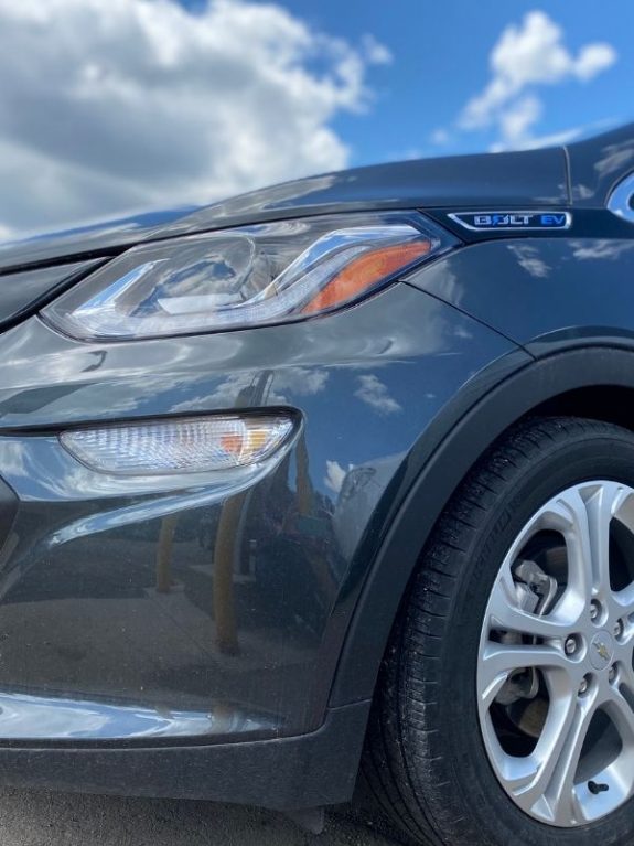 front of a Chevy Bolt + clouds