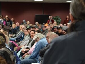 The back of a person speaking and the crowd of attendees at the Upper Sioux Community Land Transfer meeting in Granite Falls on Wednesday, April 5, 2023.