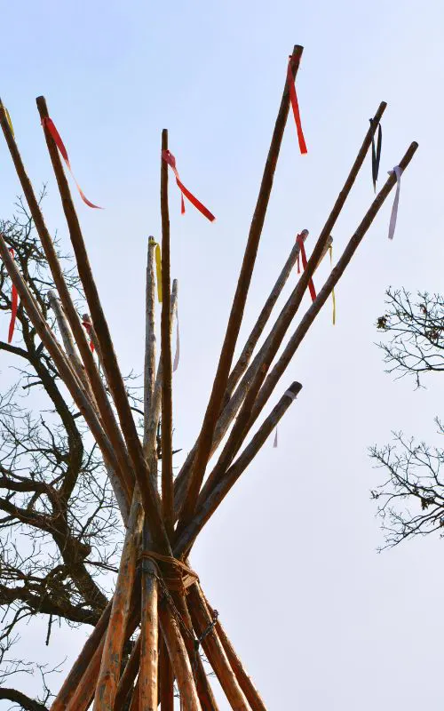 Looking up toward the sky at the sticks at the top of a tipi