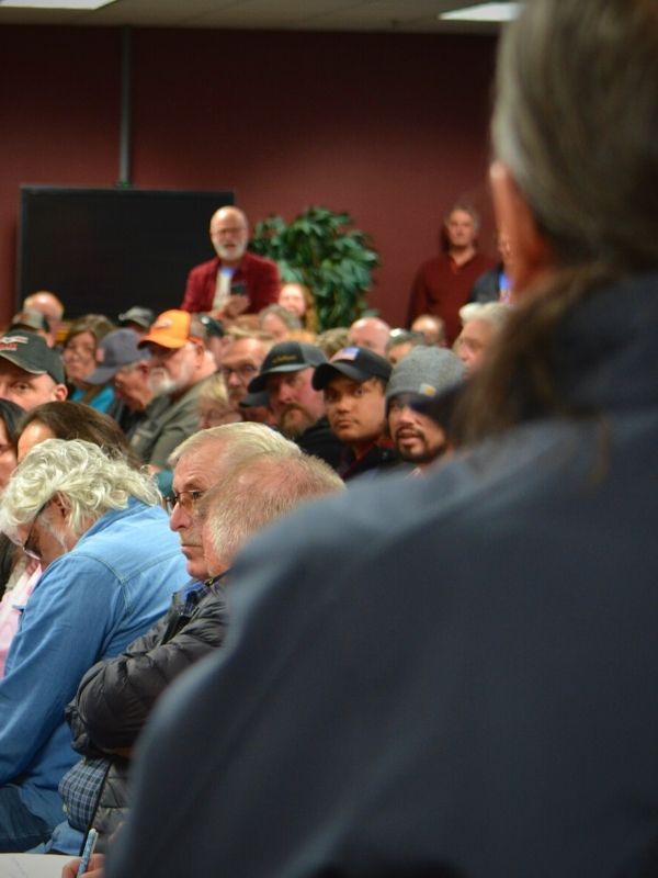 The back of a person speaking and the crowd of attendees at the Upper Sioux Community Land Transfer meeting in Granite Falls on Wednesday, April 5, 2023.
