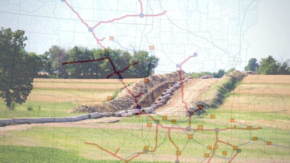 A pipeline being constructed through a farm field with the map of CO2 pipelines overlaid over it.