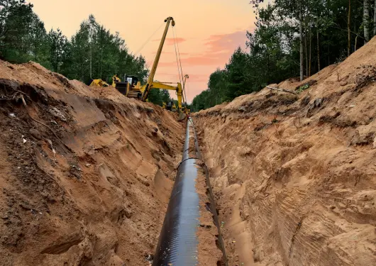 Machine digging a pipeline into the ground