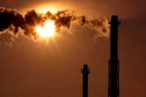 Polluting Smokestacks Silhouetted in the Sun