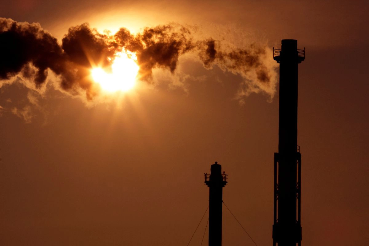 Polluting Smokestacks Silhouetted in the Sun