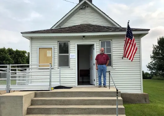 Man standing outside of a rural town hall