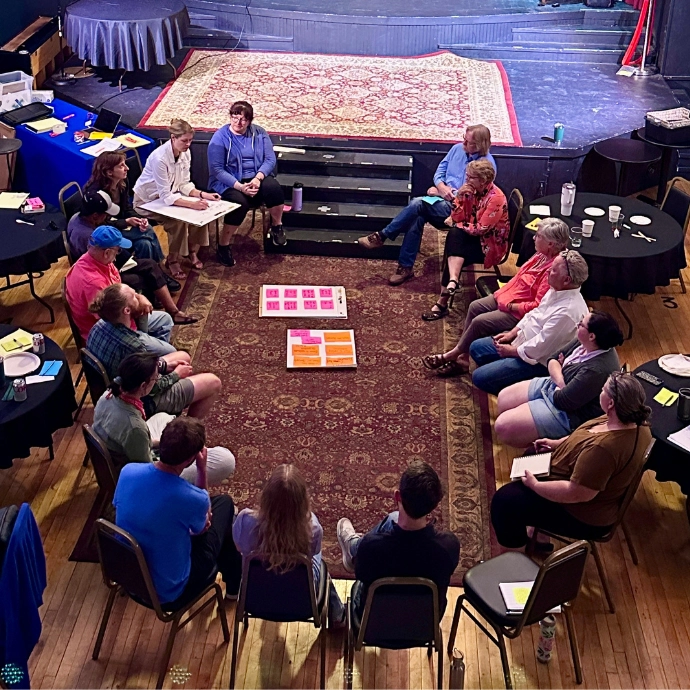 People sitting in a circle at the Little Threatre in New London