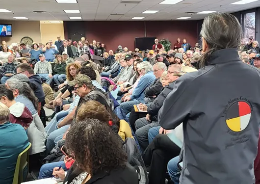 Man addressing crowded room