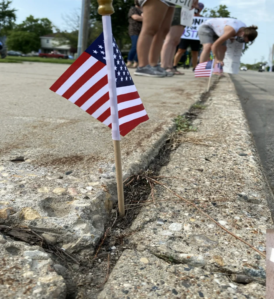 Small American Flag stuck into sidewalk crack