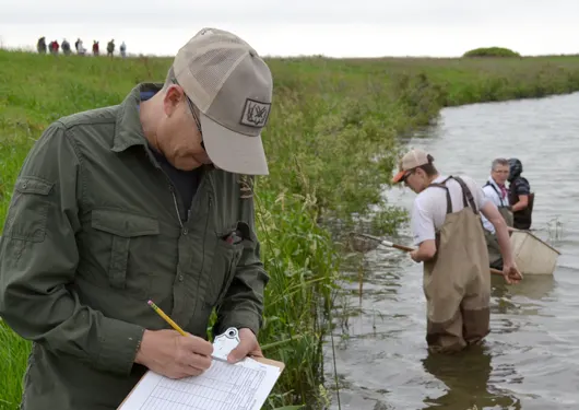 People outdoors testing water