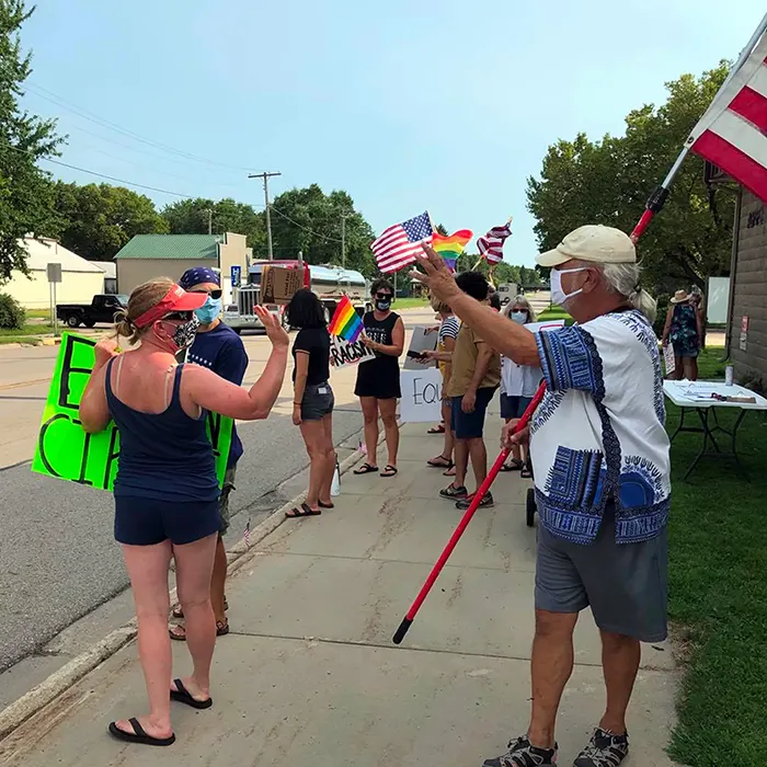 Demonstrators with signs and flags on a sidewalk