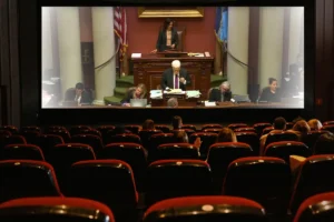 People in theater seats watching the Minnesota legislature on-screen