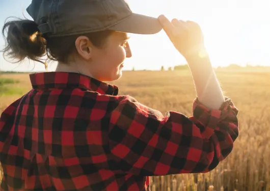 woman looking at wheat field
